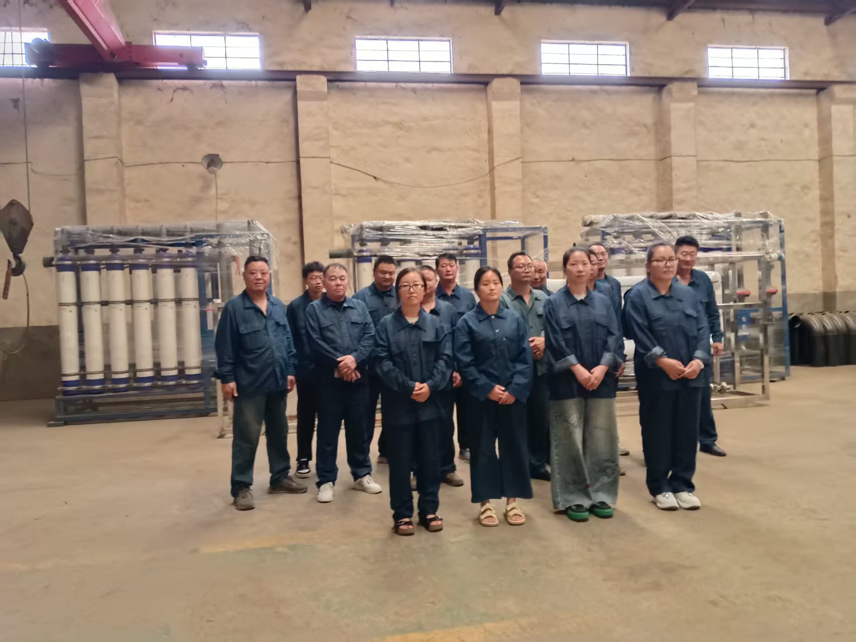 JIE NENG staff beside wrapped ultrafiltration skids in the workshop